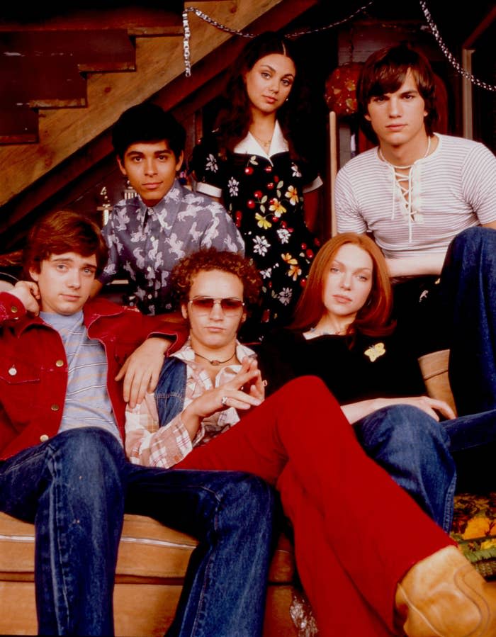 Cast of That '70s Show, sitting on or around a couch