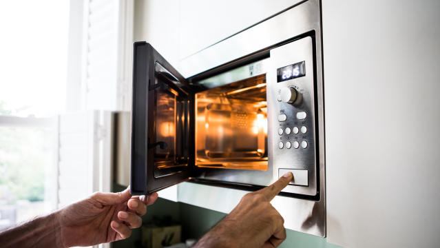person putting something in a microwave