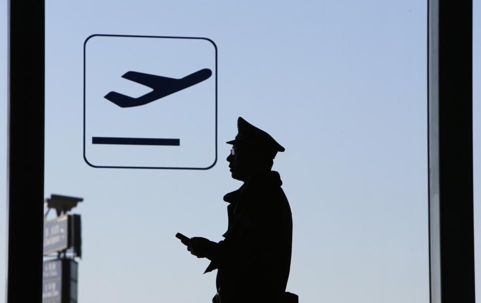 La silueta de un policía dentro del Aeropuerto Internacional de Beijing el 13 de marzo de 2014, días después que se desapareciera el avión de Malysian Airlines. Aún no se han encontrado rastros de la aeronave. REUTERS/Jason Lee