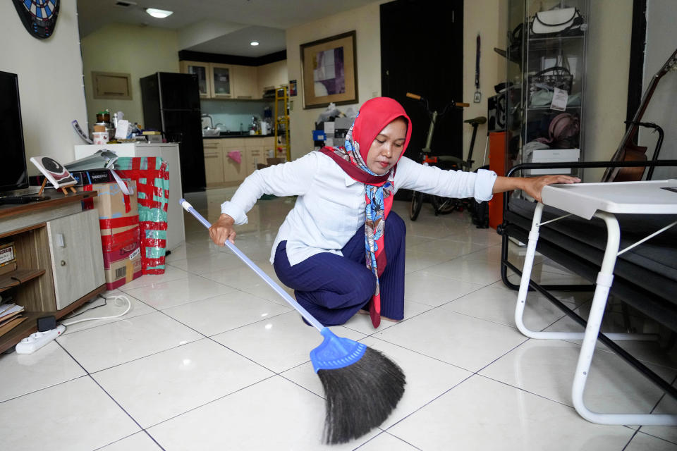 Yuni Sri Rahayu, a domestic worker who’s running for the Jakarta legislature with the new Labor Party, cleans at her employers' apartment in Jakarta, Indonesia, on Feb. 6, 2024. Despite a quota system that has helped more women into parliament, they remain under-represented in the world’s third-largest democracy, which will go to the polls for national elections Feb. 14. (AP Photo/Tatan Syuflana)