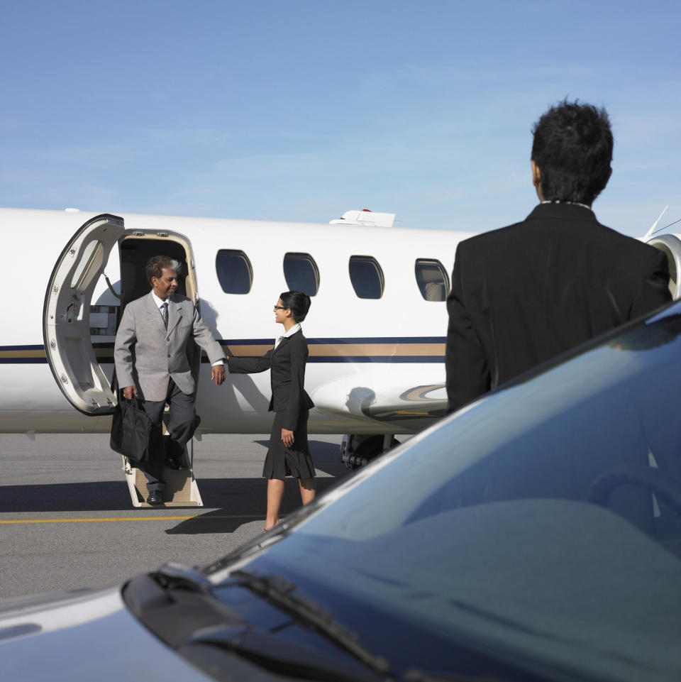 A man in a suit exiting a private plane