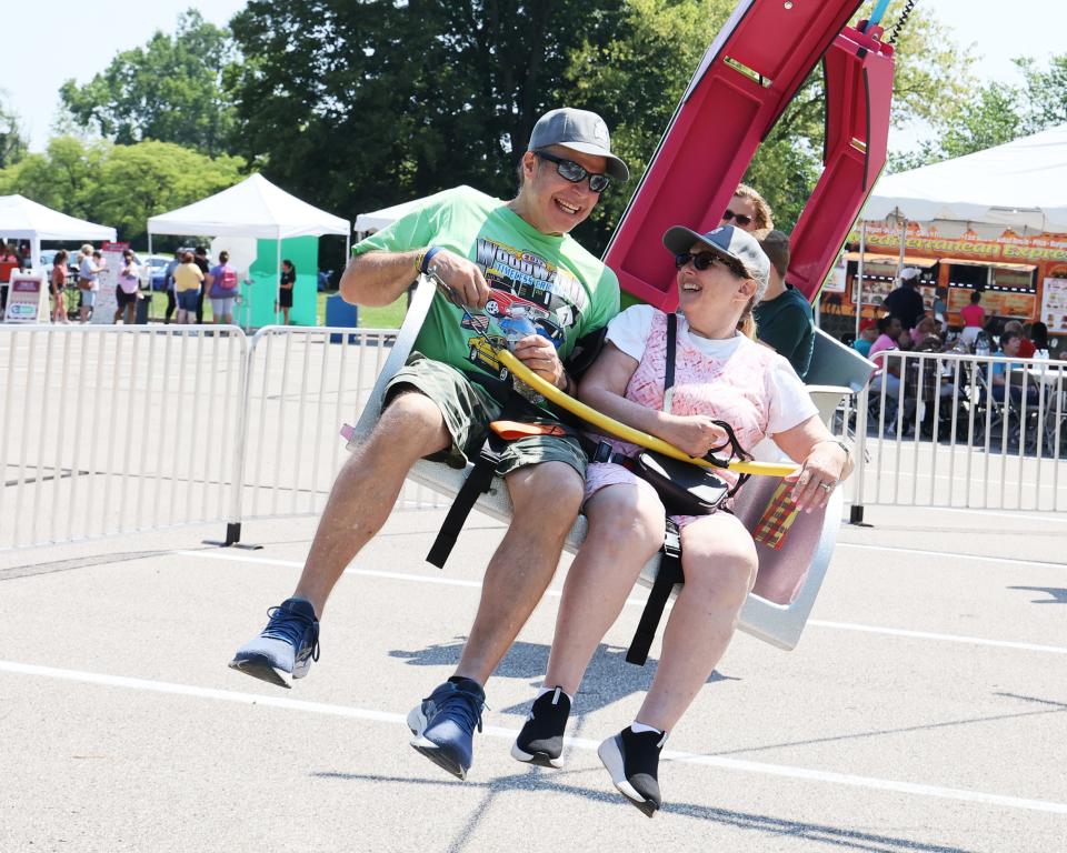 Jason and his caregiver enjoy a ride at the JARC carnival in 2023.