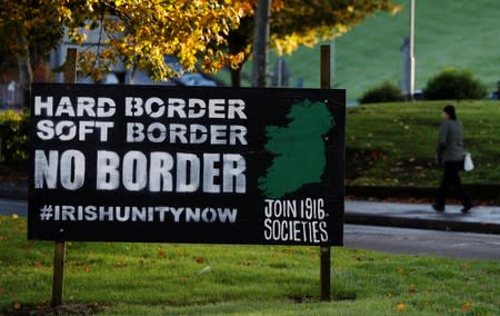 A woman walks past a 'No Border' sign in Londonderry, Northern Ireland