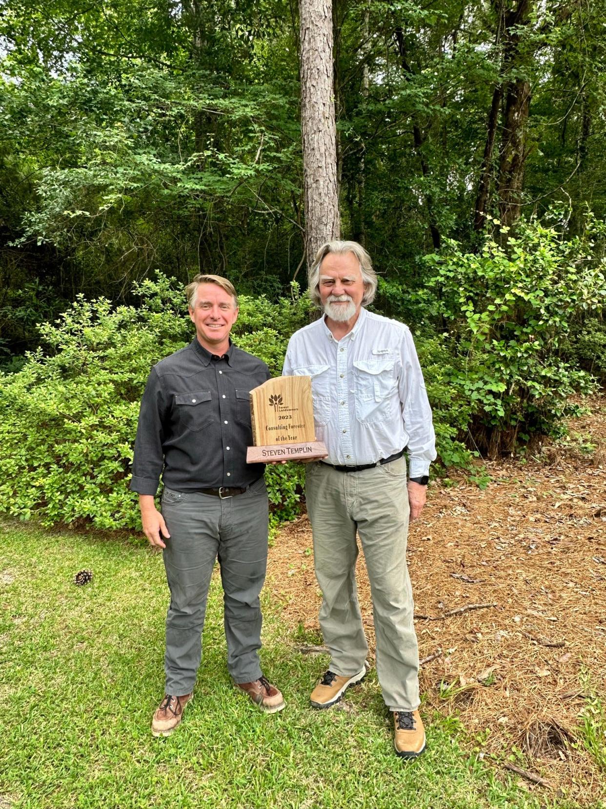 Michael Crowell (left) president of the Forest Landowners Association, gives Steve Templin his award for Consulting Forester of the Year.