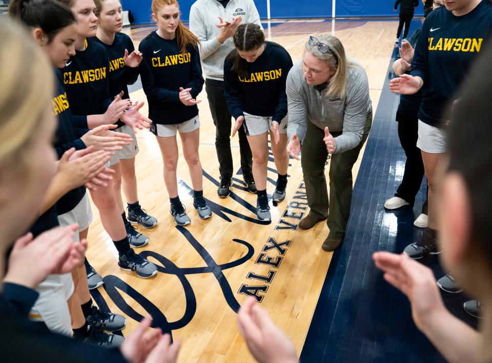 Clawson High School varsity head coach Kelly Horne gets her team fired up before they play Ferndale's University High School on Monday Feb. 5, 2024. The team huddles around former player Alex Verner's signature. Verner was killed last year by a gunman at Michigan State University. Verner is memorialized by the school who took her signature and her jersey number (24) and had it painted on their basketball court in two places.