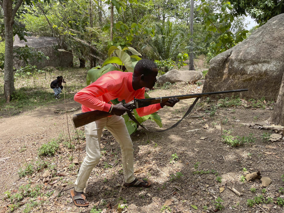 Joshua Danjuma, 36, poses with a handcrafted riffle in Kunji Village, Southern Kaduna Nigeria, Thursday , April 27, 2023. Danjuma, a hunter who lost two of his five children in a late night March 2023 gunmen attack that left 33 people dead, has joined others in protecting their homes. (AP Photo/Chinedu Asadu)
