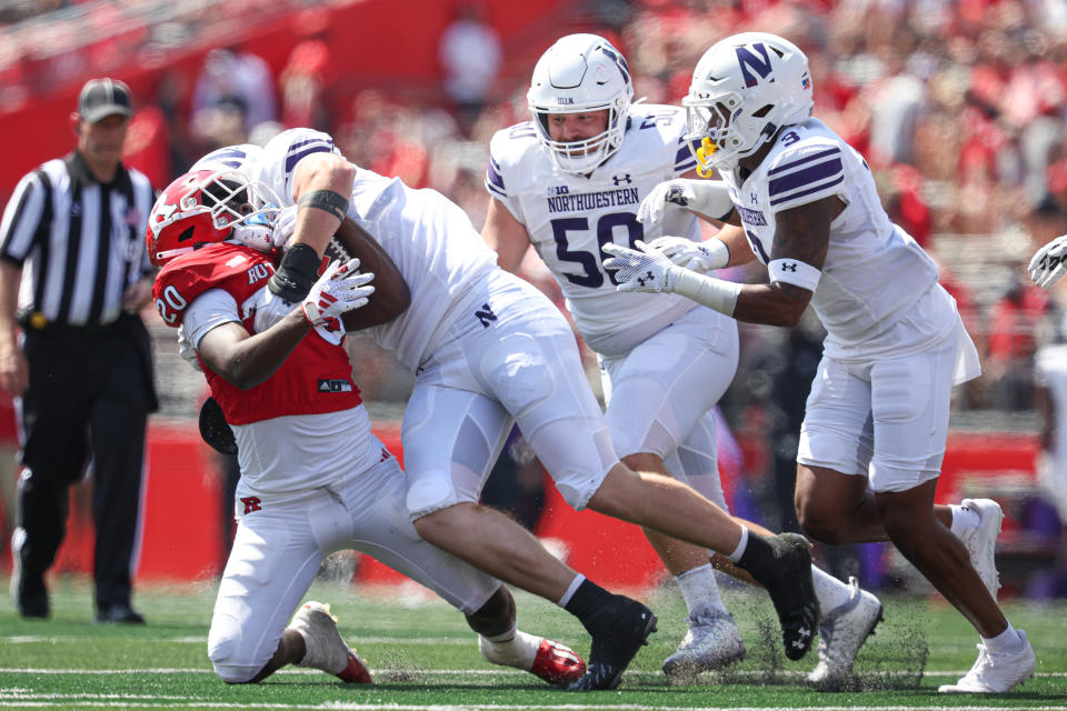 Sep 3, 2023; Piscataway, New Jersey, USA; Northwestern Wildcats defensive lineman Richie Hagarty (52) tackles Rutgers Scarlet Knights running back Ja’shon Benjamin (20) in front of defensive lineman P.J. Spencer (50) and defensive back Jaheem Joseph (3) during the first half at SHI Stadium. Mandatory Credit: Vincent Carchietta-USA TODAY Sports