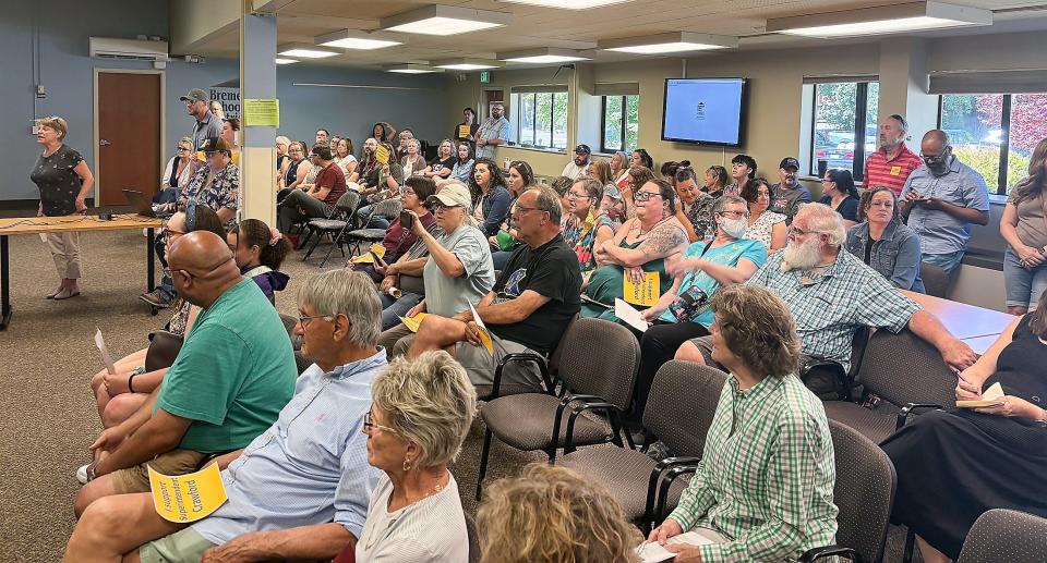 Members of the public listen during a special meeting on the Bremerton School District board on Thursday morning. In a brief session the board voted to place Superintendent James Crawford on administrative leave, and many supporters in the crowd expressed dismay at the unanimous vote.