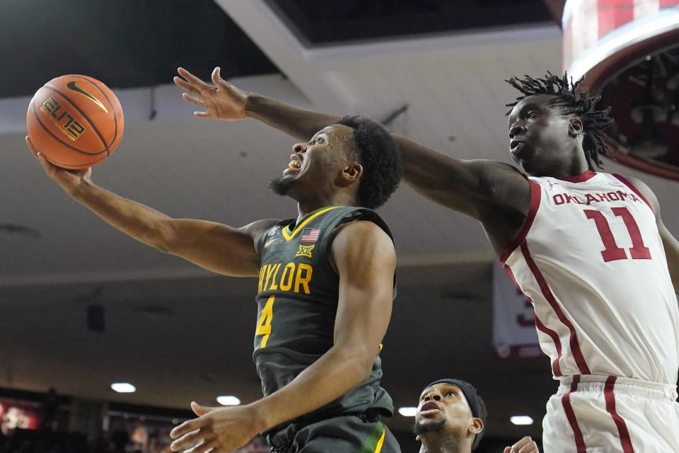Baylor guard LJ Cryer (4) goes to the basket in front of Oklahoma forward Akol Mawein (11) in the first half of an NCAA college basketball game Saturday, Jan. 22, 2022, in Norman, Okla. (AP Photo/Sue Ogrocki)