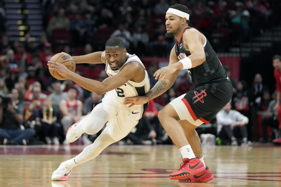 San Antonio Spurs guard Malaki Branham, left, dribbles past Houston Rockets guard Daishen Nix during the first half of an NBA basketball game, Monday, Dec. 19, 2022, in Houston. (AP Photo/Eric Christian Smith)