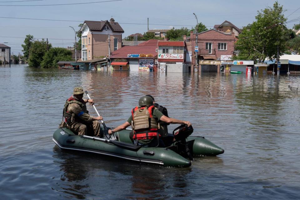 Ukrainian security forces transport local residents in a boat during an evacuation from a flooded area (AFP/Getty)