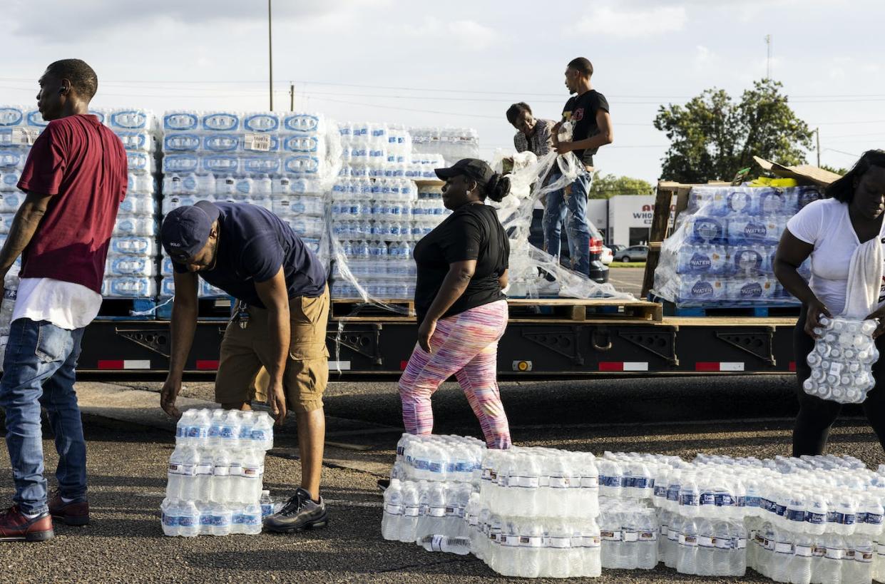 Volunteers distributed bottled water after Jackson, Mississippi's water treatment plant failed during flooding in August 2022. <a href="https://www.gettyimages.com/detail/news-photo/cases-of-bottled-water-are-handed-out-at-a-mississippi-news-photo/1242850326?adppopup=true" rel="nofollow noopener" target="_blank" data-ylk="slk:Brad Vest/Getty Images;elm:context_link;itc:0;sec:content-canvas" class="link ">Brad Vest/Getty Images</a>