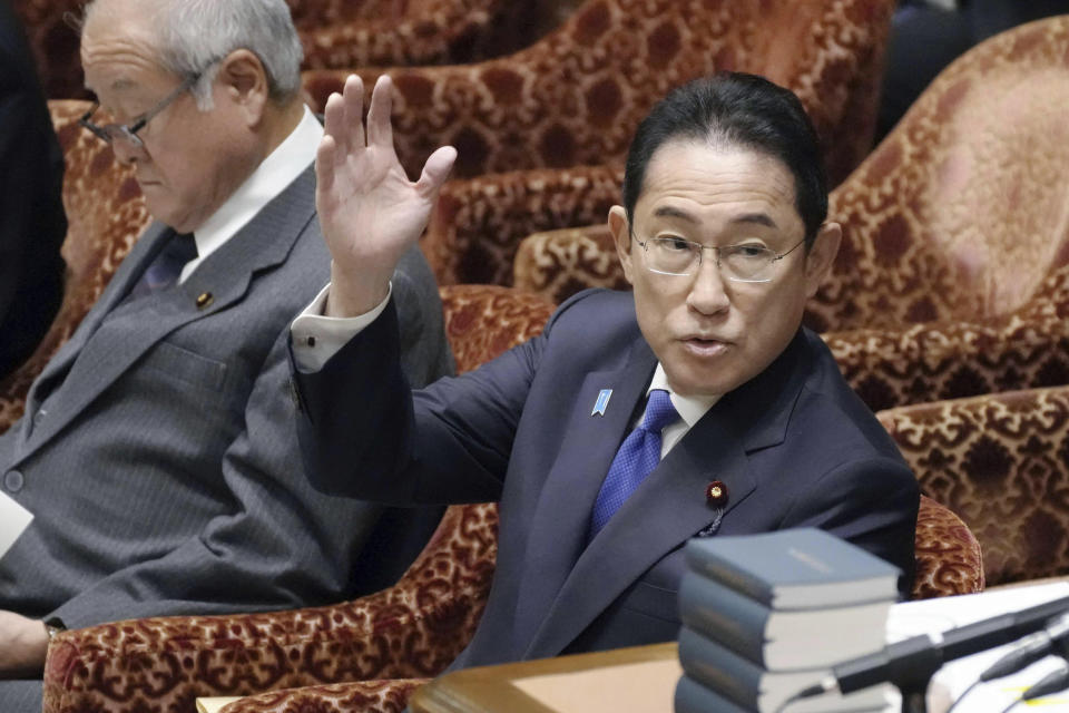 Japanese Prime Minister Fumio Kishida raises his hand before he speaks about his Liberal Democratic Party's funds scandal during a meeting of the Lower House Budget Committee in Tokyo Monday, Jan. 29, 2024. Kishida on Monday was forced to start this year's parliamentary session with an apology over one of the country's biggest corruption scandals in decades. (Kyodo News via AP)