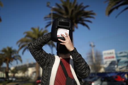 A mas uses a protective mask to observe a solar eclipse at La Serena