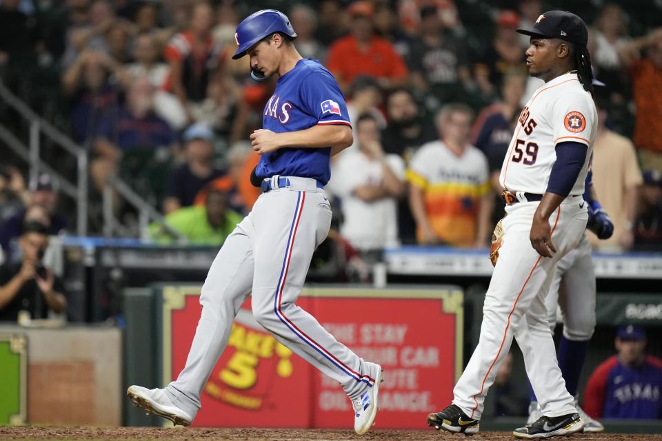 Texas Rangers' Corey Seager, left, scores on a wild pitch by Houston Astros starting pitcher Framber Valdez (59) during the seventh inning of a baseball game, Tuesday, Sept. 6, 2022, in Houston. (AP Photo/Eric Christian Smith)