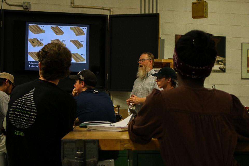 Garrick Green, a professor at McPherson College,  explains vehicle woodworking concepts to his students.