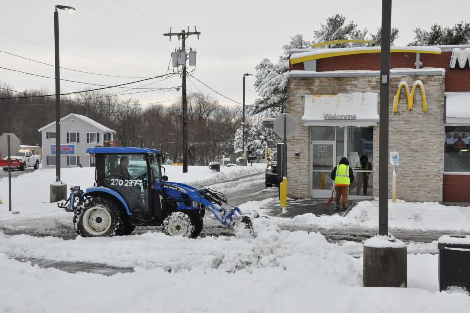 A tractor driver plows the McDonald's parking lot on Route 13 in Smyrna Jan. 3, 2022.