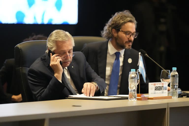 Alberto Fernández habla por teléfono junto a Santiago Cafiero durante la cumbre del Mercosur 