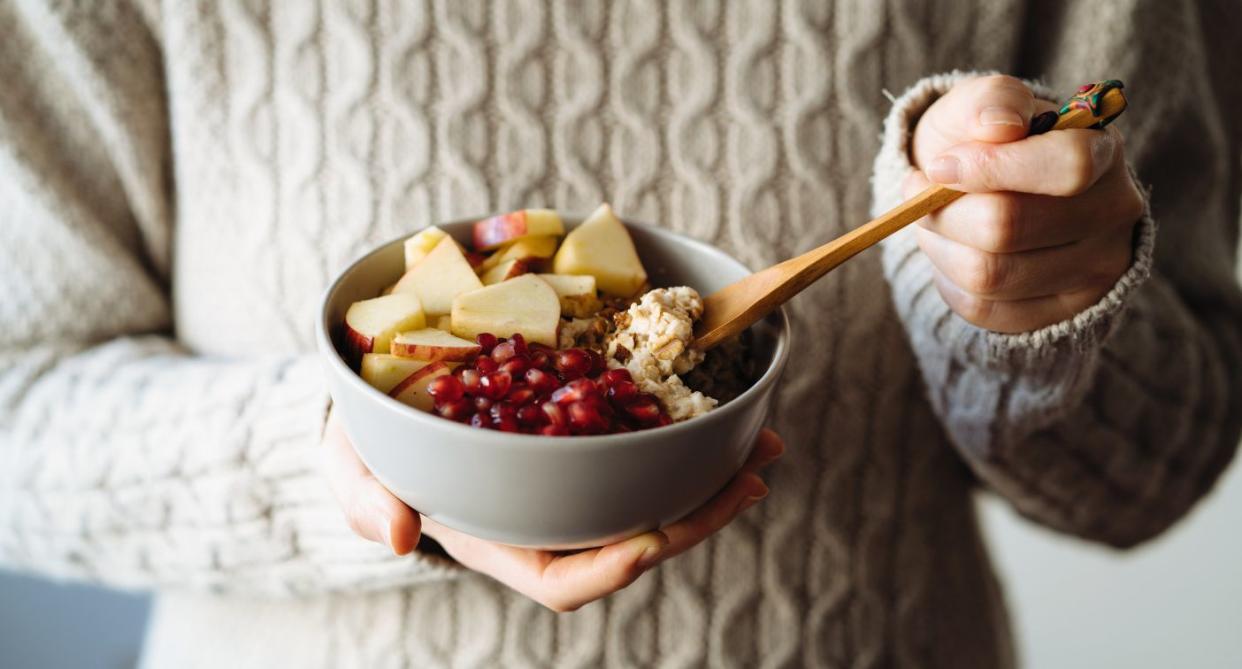 Bowel cancer diet, woman eating fruit and porridge in a bowel. (Supplied)