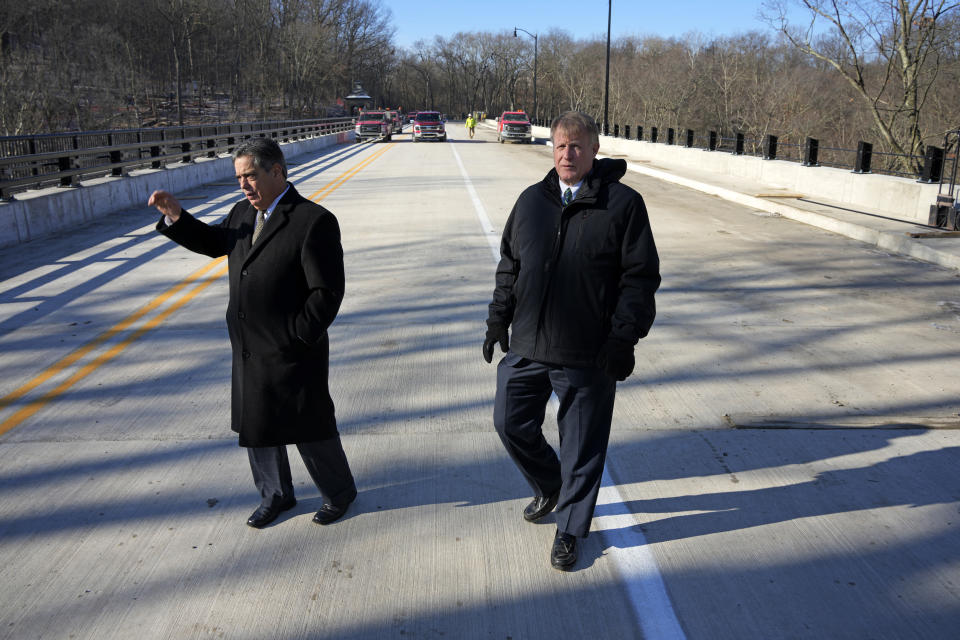 Pennsylvania State Senator Jay Costa, left, and Allegheny County Executive Rich Fitzgerald walk on the rebuilt Fern Hollow Bridge in Pittsburgh before a dedication ceremony on Wednesday, Dec. 21, 2022. The original bridge collapsed during a snow storm on Jan. 28, 2022. The collapse of the Fern Hollow Bridge became a symbol of the country's troubled infrastructure. (AP Photo/Gene J. Puskar)