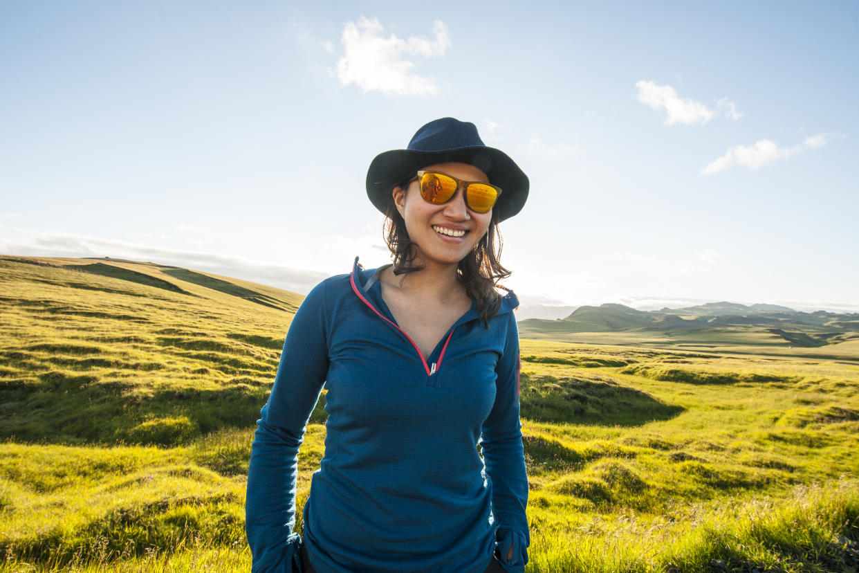 Woman wearing sunglasses and hat enjoying a sunny day in Iceland. (Photo: Getty)