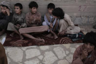 In this July 27, 2018, photo, 14 year-old Abdel Hamid, second right, and 14 year-old Morsal, third right, sit at a camp for displaced persons where they took shelter, in Marib, Yemen. Both boys were child solders forcibly enlisted by Houthi rebels and put to work carrying ammunition and supplies to the front lines. Abdel-Hamid says he saw children get shot for disobeying orders. Morsal suffered partial hearing loss from explosions and airstrikes. (AP Photo/Nariman El-Mofty)