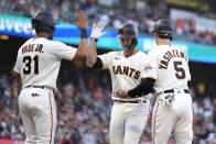 San Francisco Giants' Buster Posey, center, is congratulated by teammates LaMonte Wade Jr (31) and Mike Yastrzemski (5) after hitting a three-run home run against the Arizona Diamondbacks during the first inning of a baseball game Wednesday, June 16, 2021, in San Francisco. (AP Photo/Tony Avelar)