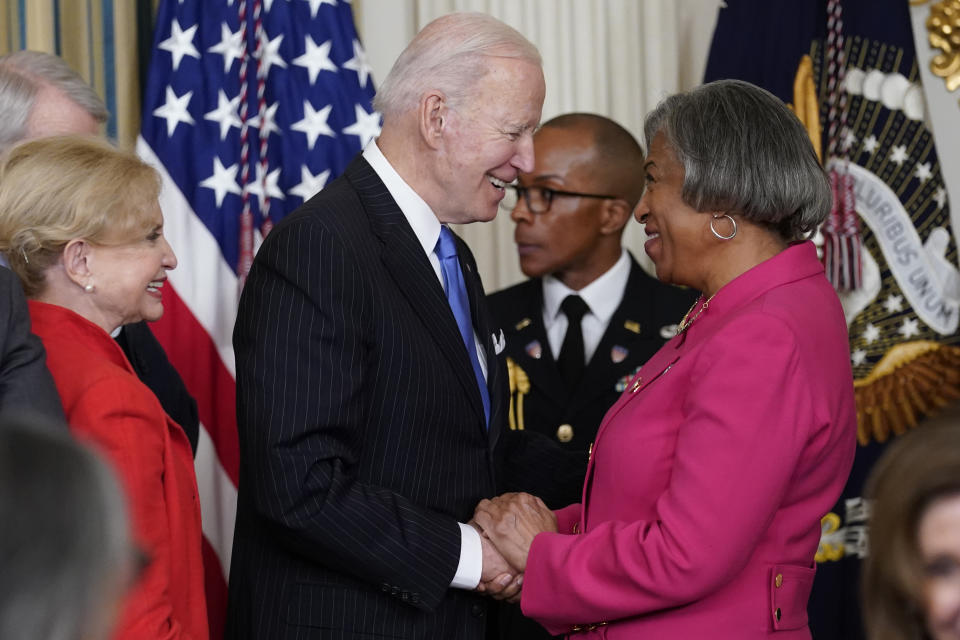 President Joe Biden talks talks with Rep. Brenda Lawrence, D-Mich., after signing the Postal Service Reform Act of 2022 in the State Dining Room at the White House in Washington, Wednesday, April 6, 2022. At left is Rep. Carolyn Maloney, D-N.Y. (AP Photo/Susan Walsh)