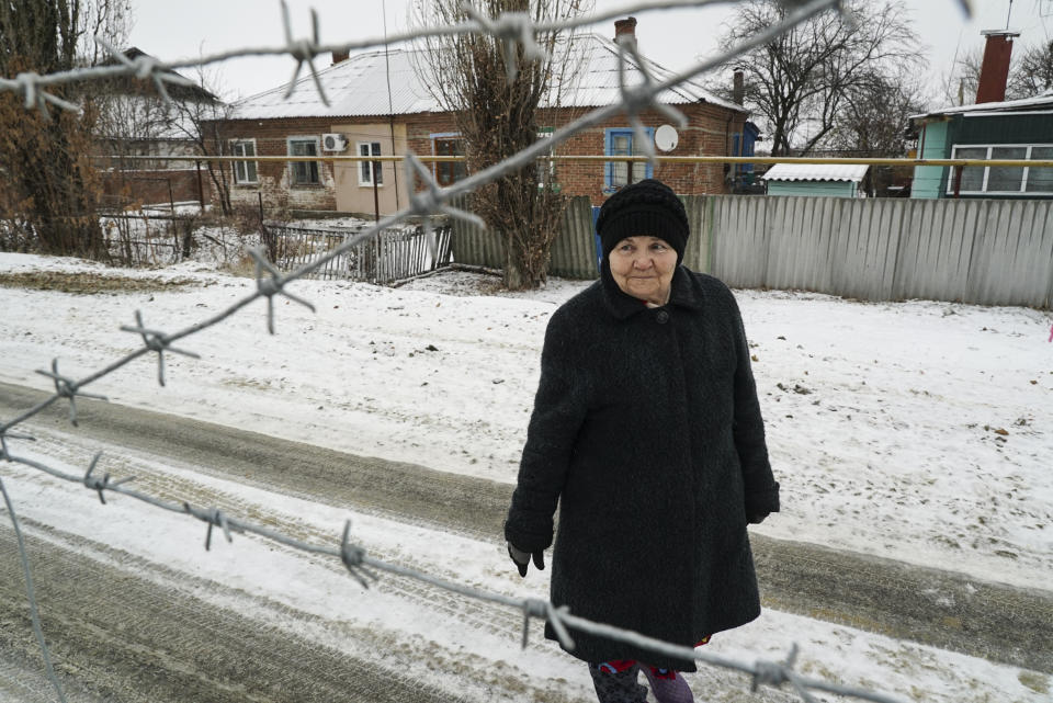 Raisa Yakovleva, waits to see her Ukrainian sister Valentina Boldyrevastands standing behind barbed wire on the Russian side of the Russia-Ukraine border as a Ukrainian border guard patrols an area in Milove town, eastern Ukraine, Sunday, Dec. 2, 2018. Valentina Boldyreva stepped out of her two-storey house on an overcast and snowy December afternoon to say hello to her 76-year-old sister who lives on the other side of Friendship of People's Street, a three-meter barbed-wire fence separating Russia from Ukraine and separating these sisters from each other. (AP Photo/Evgeniy Maloletka)