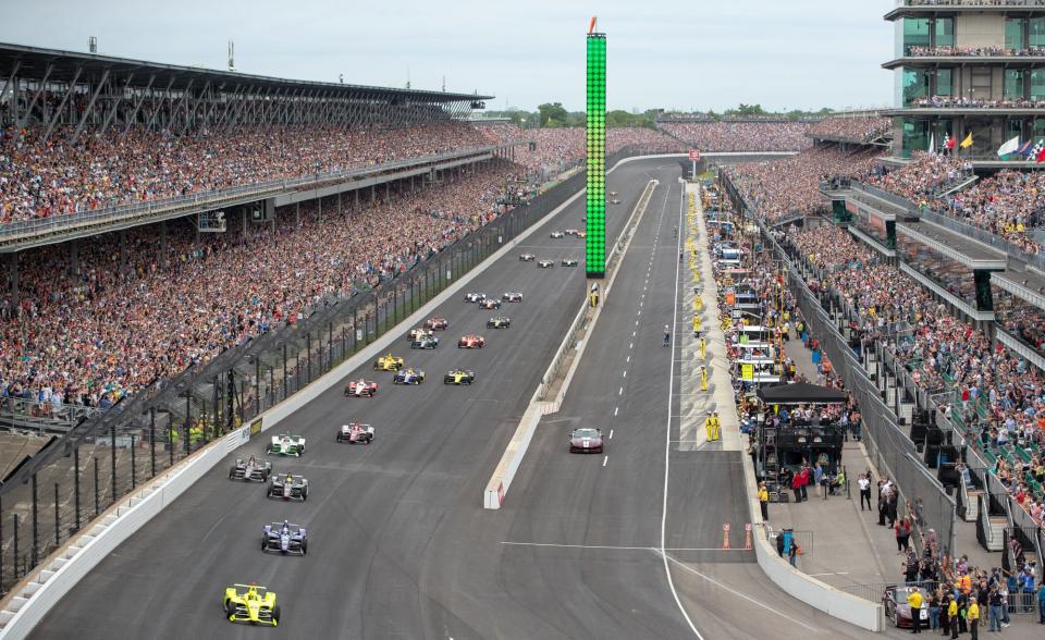 The green flag waves as drivers make their way to the starting line during the 103rd running of the Indianapolis 500 on Sunday, May 26, 2019.