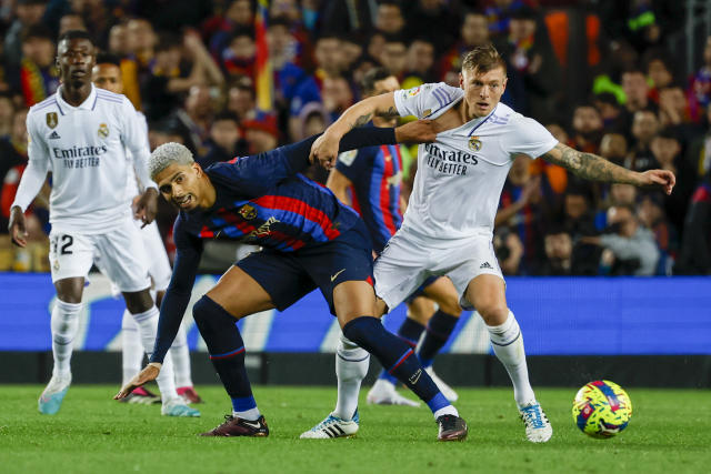 Real Madrid's Toni Kroos, right, and Barcelona's Ronald Araujo fight for the ball during Spanish La Liga soccer match between Barcelona and Real Madrid at the Camp Nou stadium in Barcelona, Spain, Sunday, March 19, 2023. (AP Photo/Joan Monfort)