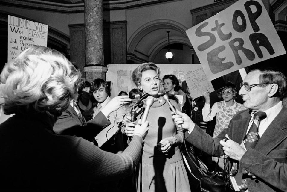 Woman addresses crowd of reporters