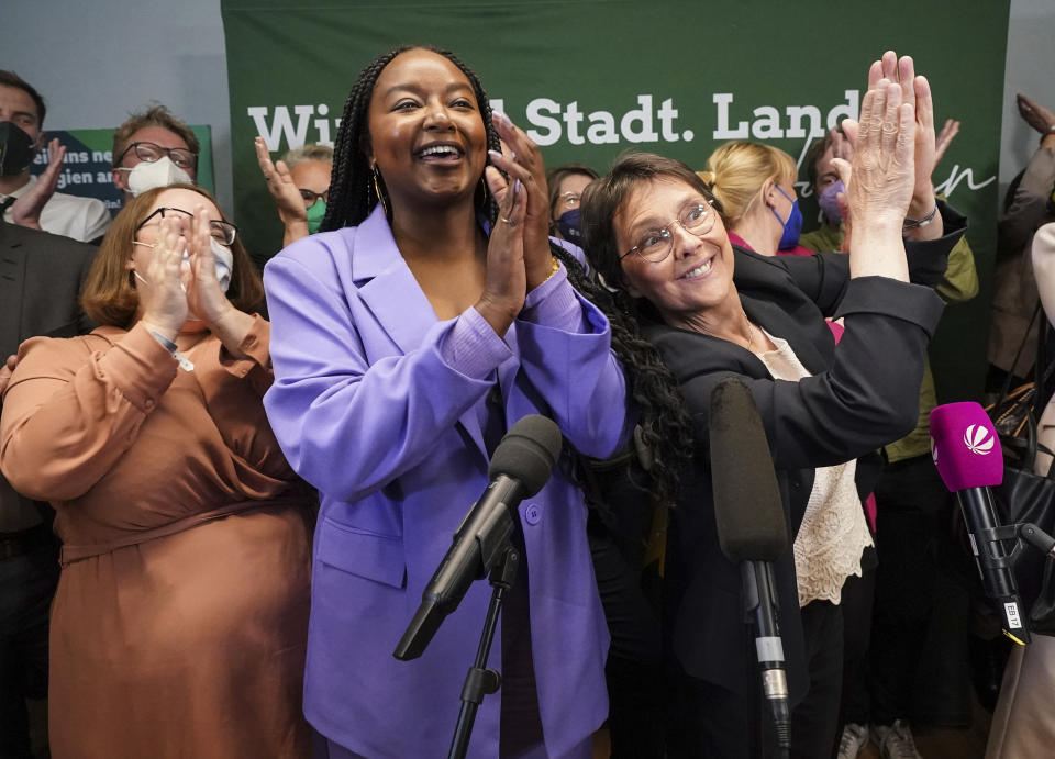 Schleswig-Holstein's Finance Minister Monika Heinold, right, top candidate for the Green Party, cheers with Aminata Toure after the first forecasts for the state election in Schleswig-Holstein were announced, in Kiel, Germany, Sunday, May 8, 2022. (Marcus Brandt/dpa via AP)