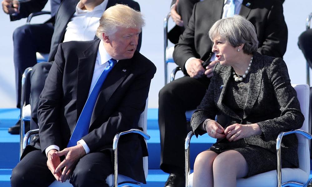 Britain’s prime minister, Theresa May, talks to Donald Trump before the Nato summit meeting on Thursday in Brussels.
