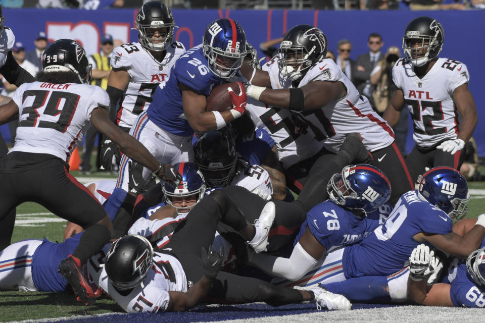New York Giants running back Saquon Barkley (26) pushes through a scrum for a touchdown during the second half of an NFL football game against the Atlanta Falcons, Sunday, Sept. 26, 2021, in East Rutherford, N.J. (AP Photo/Bill Kostroun)