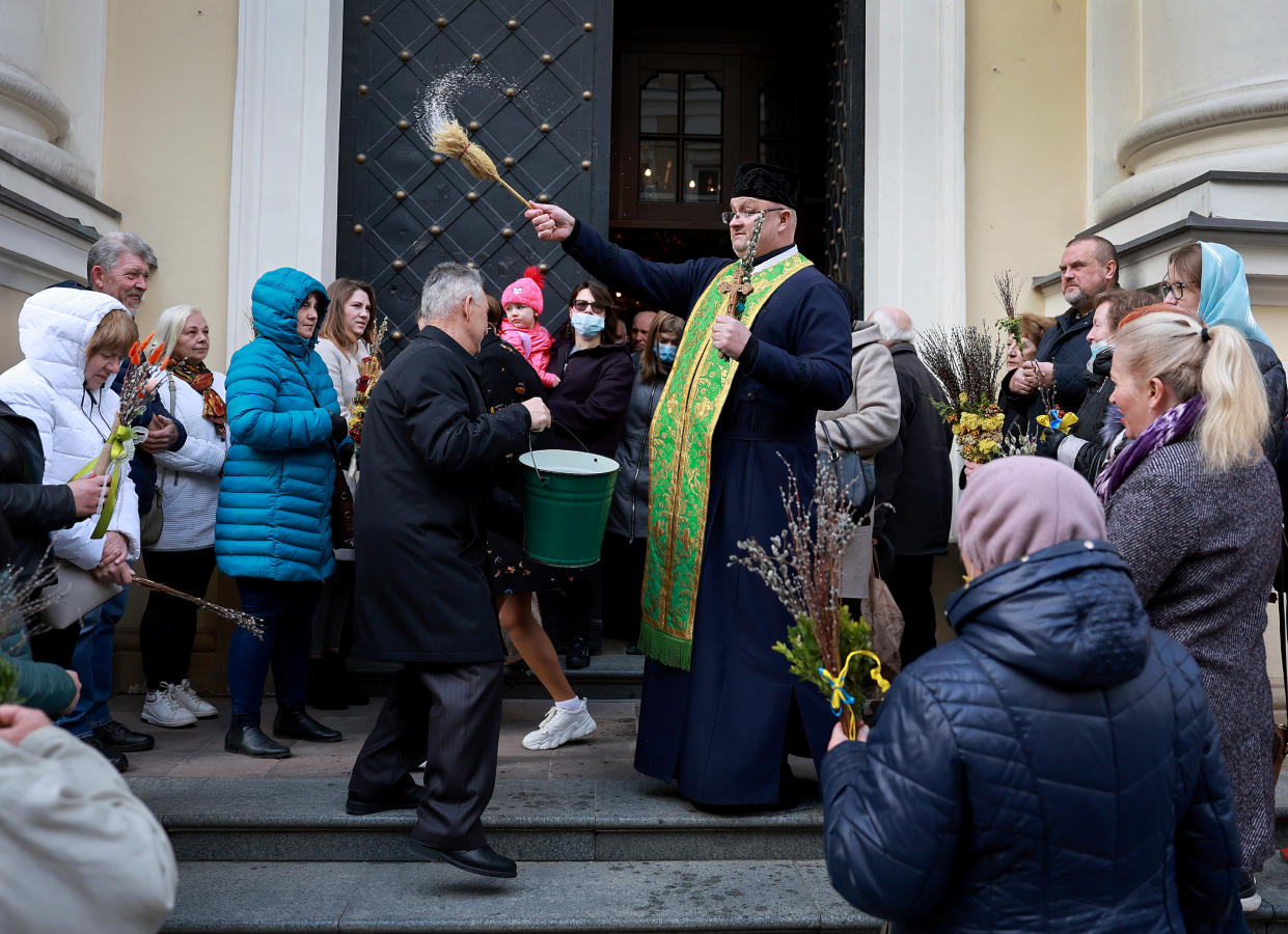 An Orthodox priest blesses parishioners with water on Palm Sunday.