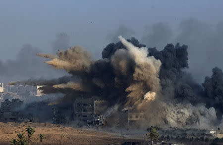 An explosion during an Israeli strike in the northern Gaza Strip is pictured from the Israeli border with Gaza, early morning July 26, 2014, before a cease-fire takes effect. REUTERS/Ronen Zvulun