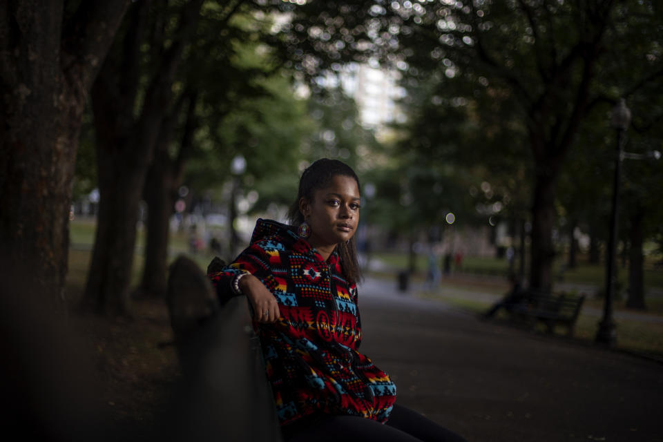 Alyssa Harris, 18, a member of the Mashpee Wampanoag Tribe, sits for a portrait in a park in Boston, Friday, Oct. 2, 2020. "I just feel like this is the four hundredth anniversary of colonization. And I mean, why why would I celebrate that? Like, celebrating getting my culture, language, land taken away? Four hundred years ago was the start of all that," said Harris who also works as a historical educator. "But then on top of that, since there's this anniversary, I've been given the opportunity to use my voice, whereas in prior years I've never been asked to. I definitely think people will listen more, especially because there's the Black Lives Matter movement, which is already influencing people to learn more about history." (AP Photo/David Goldman)