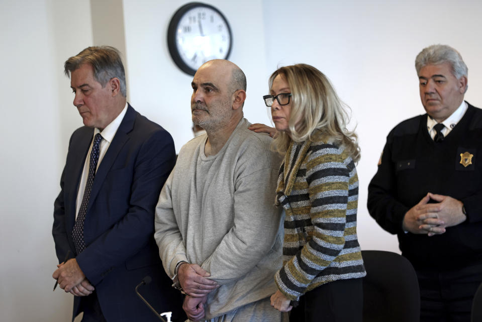 Dean Kapsalis is comforted by his attorneys Jack Cunha, left, and Helen Holcomb, as his sentence is read during a hearing at Middlesex Superior Court, Wednesday, Jan. 17, 2024, in Woburn, Mass. Kapsalis, convicted in the 2021 killing of Henry Tapia, a Black man, following a road rage encounter in which he yelled a racial slur, was sentenced to life in prison with possibility of parole after 15 years. (David L. Ryan/The Boston Globe via AP, Pool)