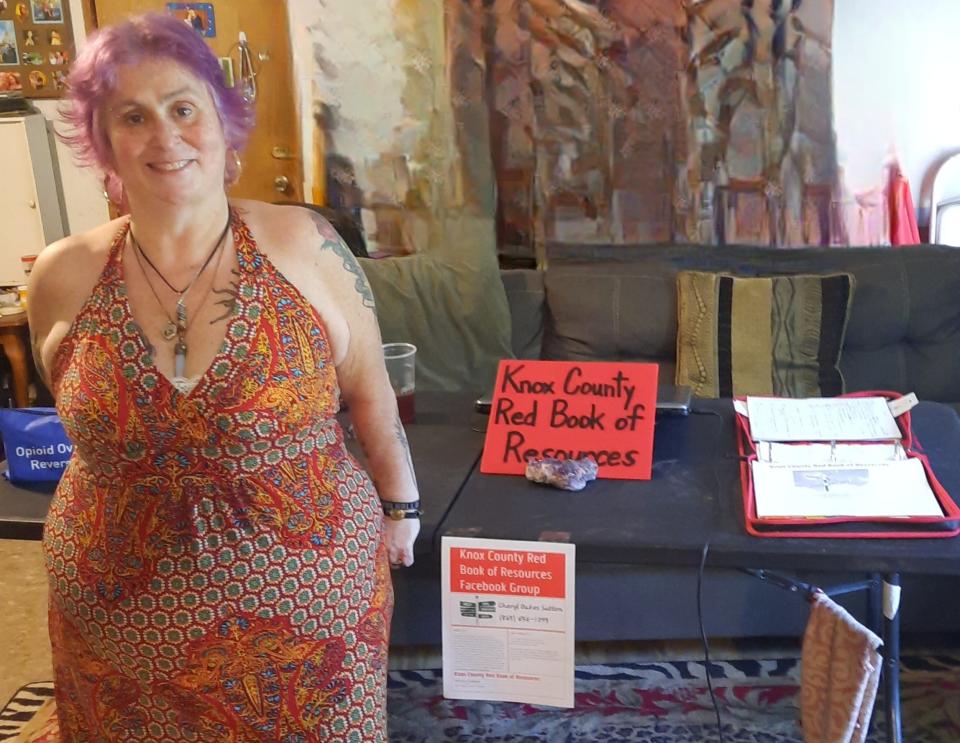 Cheryl Sutton poses near the original "red book," before the information was put online.