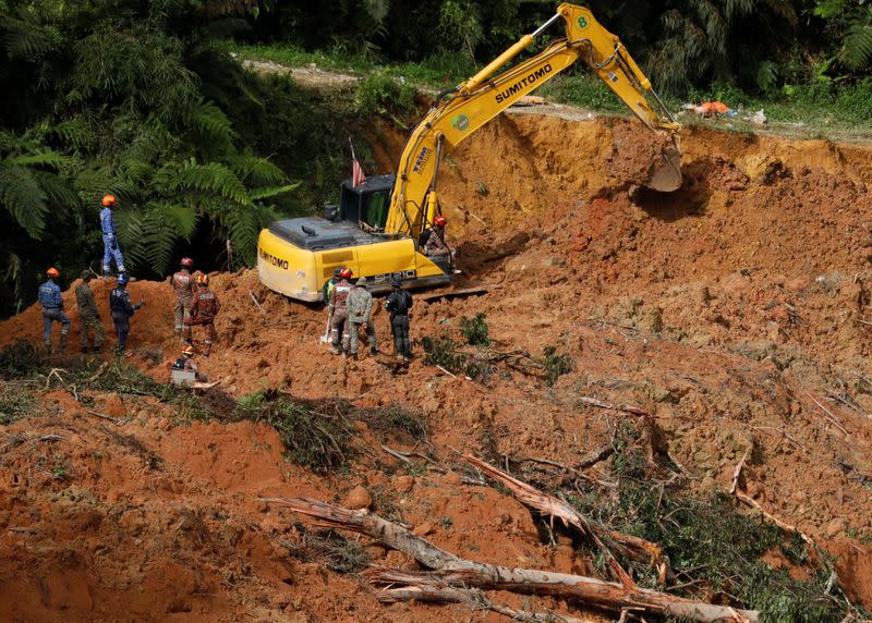 Rescuers work during a rescue and evacuation operation following a landslide at a campsite in Batang Kali