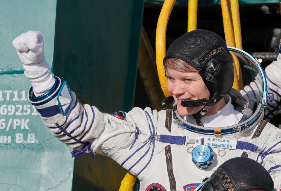 NASA astronaut Anne McClain, a member of the International Space Station (ISS) expedition 58/59, gestures as she boards the Soyuz MS-11 spacecraft shortly before the launch at the Russian-leased Baikonur cosmodrome in Kazakhstan on December 3, 2018.