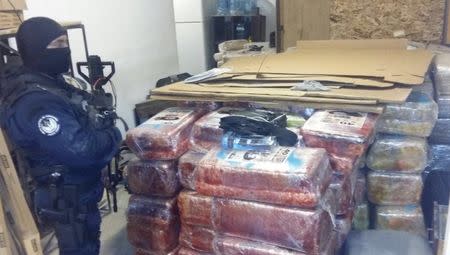 A police officer guards packages of seized marijuana in this undated photograph provided by Mexico's Federal Police, October 22, 2015. REUTERS/Mexico's Federal Police/Handout