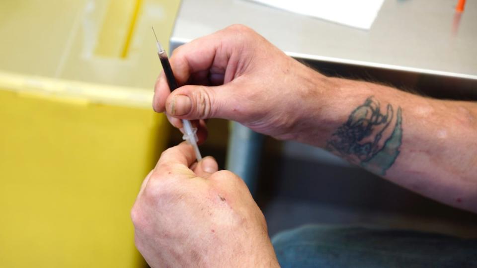 Closeup of opioid user holding needle        