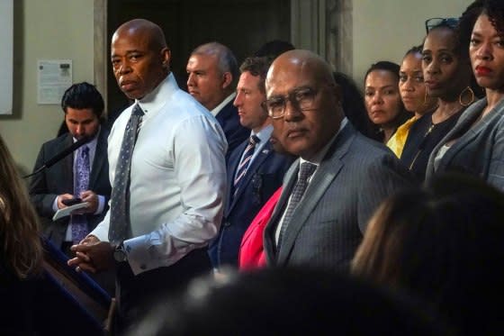 New York Mayor Eric Adams, left, and city officials listen to a reporter’s question during a City Hall press conference, on Aug. 9, 2023.<span class="copyright">Bebeto Matthews—AP</span>