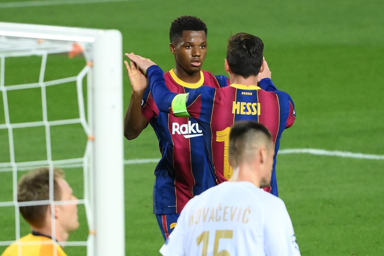 Barcelona's Spanish forward Ansu Fati (C) celebrates with Barcelona's Argentine forward Lionel Messi after scoring a goal during the UEFA Champions League football match between FC Barcelona and Ferencvarosi TC at the Camp Nou stadium in Barcelona on October 20, 2020. (Photo by LLUIS GENE / AFP) (Photo by LLUIS GENE/AFP via Getty Images)