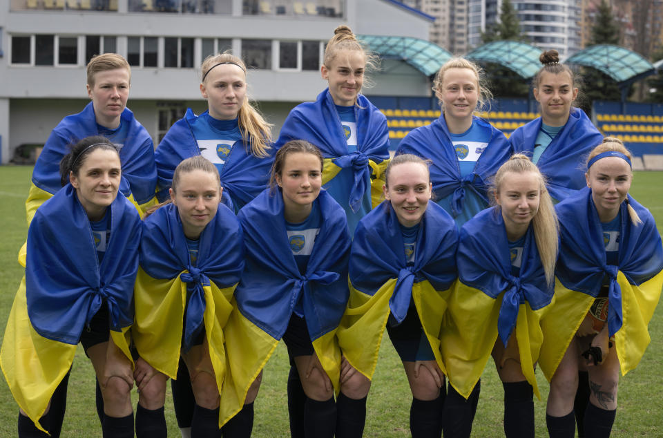 Players of a women's football team from Mariupol pose for photo before a Ukrainian championship match against Shakhtar in Kyiv, Ukraine, Tuesday, April 18, 2023. After their city was devastated and captured by Russian forces, the team from Mariupol rose from the ashes when they gathered a new team in Kyiv. They continue to play to remind everyone that despite the occupation that will soon hit one year, Mariupol remains a Ukrainian city. (AP Photo/Efrem Lukatsky)