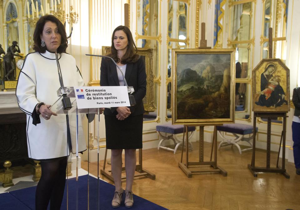 Granddaughter of the Baron Cassel van Doorn, Chilean Jacqueline Domeyko, left, speaks during a ceremony to return three paintings taken from their owners during World War ll, while France’s culture minister Aurelie Filipetti, stands next at the Culture Ministry in Paris, Tuesday, March 11, 2014. The restitution is part of France's ongoing effort to return hundreds of looted artworks that Jewish owners lost during the war that still hang in the Louvre and other museums. (AP Photo/Michel Euler)