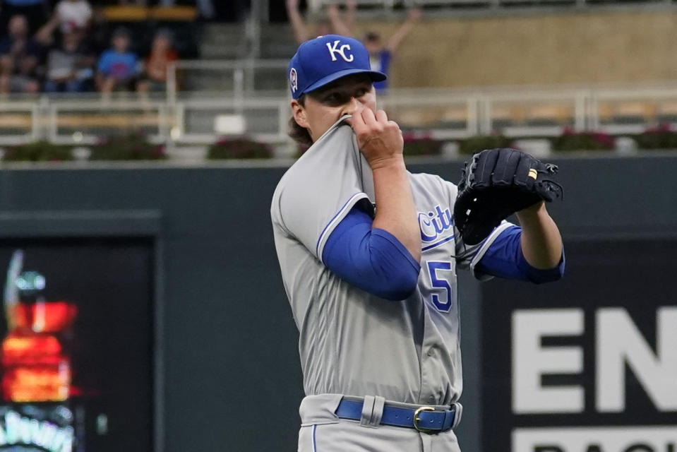 Kansas City Royals pitcher Brady Singer wipes his face after giving up a solo home run to Minnesota Twins' Byron Buxton in the first inning of a baseball game, Saturday, Sept. 11, 2021, in Minneapolis. (AP Photo/Jim Mone)