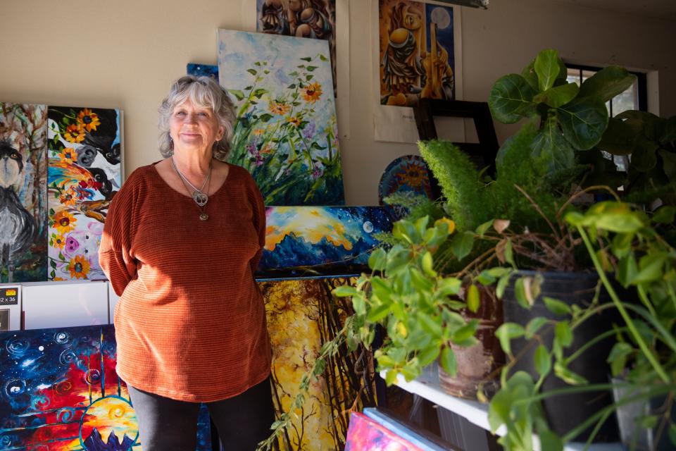 Local artist Vicki Crouse Henley poses for a portrait next to her paintings on Tuesday, Jan. 16, 2024, at her home. The LCIFF board announced that she will be this year’s poster artist for the Las Cruces International Film Festival.